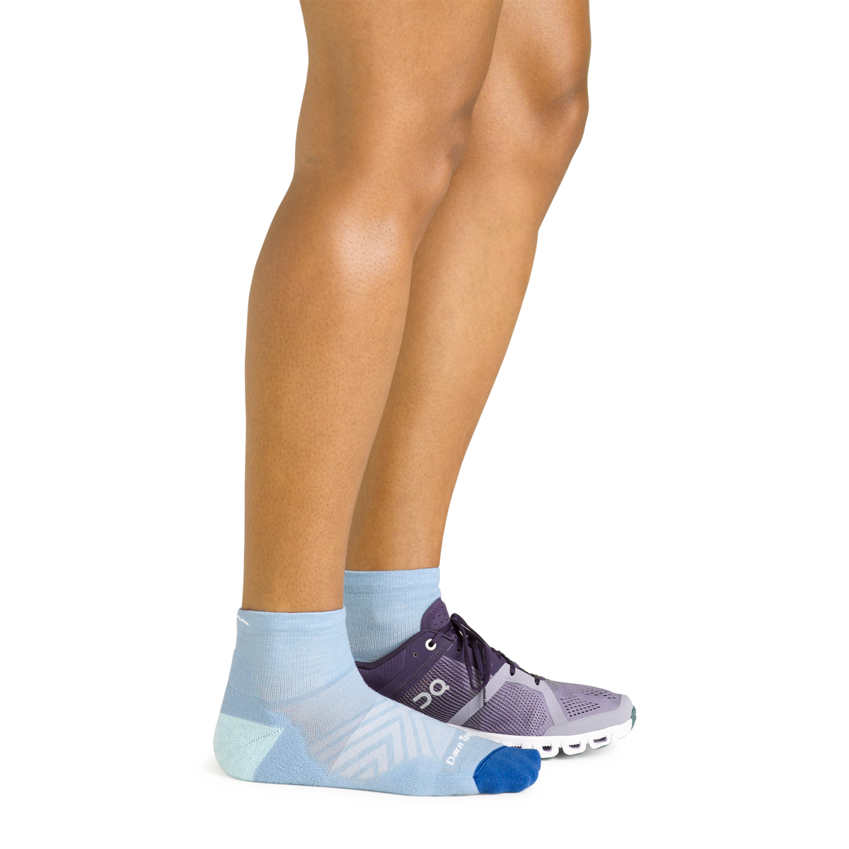 Darn Tough women's Run Quarter sock in Sky worn with a running shoe on one foot