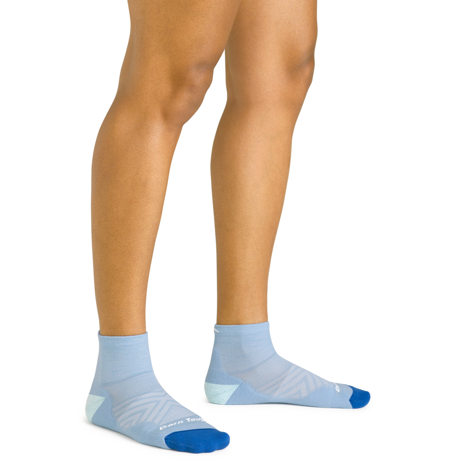 Darn Tough women's Run Quarter sock in Sky worn on feet, showing the quarter-height cuff