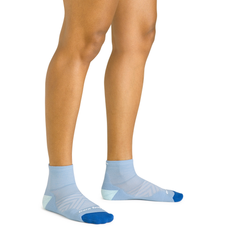 Darn Tough women's Run Quarter sock in Sky worn on feet, showing the quarter-height cuff