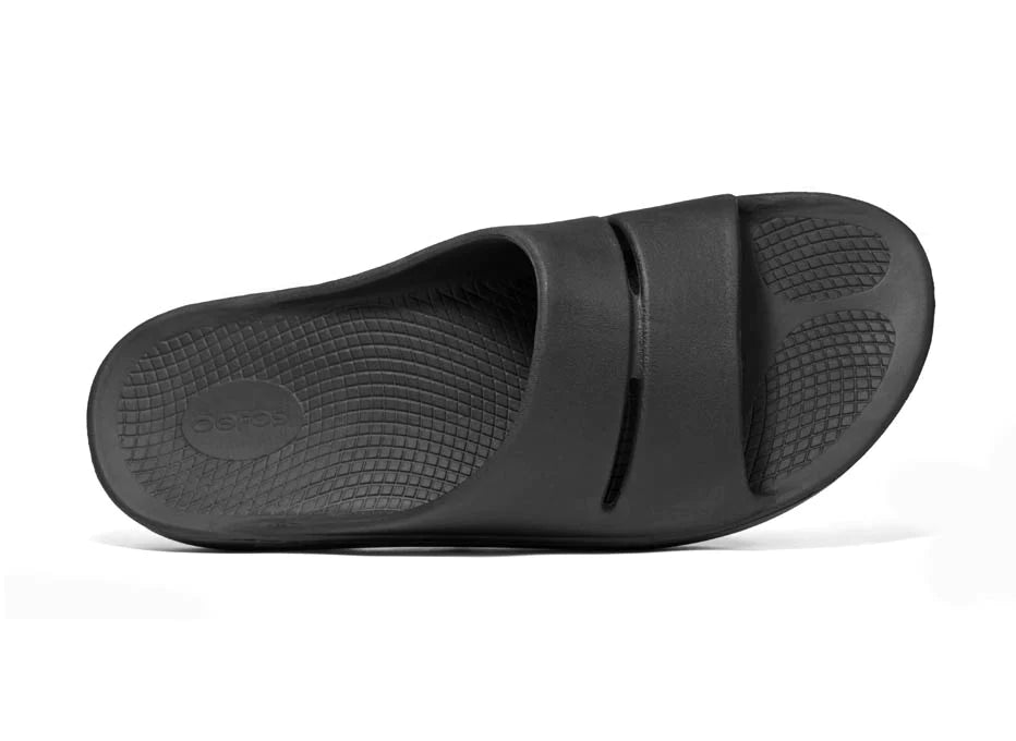 OOahh - Unisex by Oofos in black with OOfoam strap for impact absorption, supportive unisex slides ideal for recovery and casual wear
