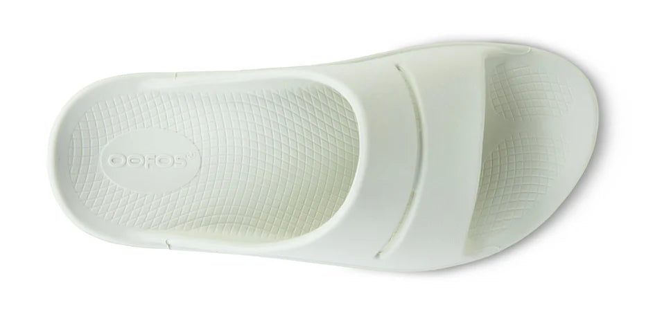 OOahh - Unisex by Oofos in white, lightweight slide with OOfoam strap for impact absorption and all-day support and comfort