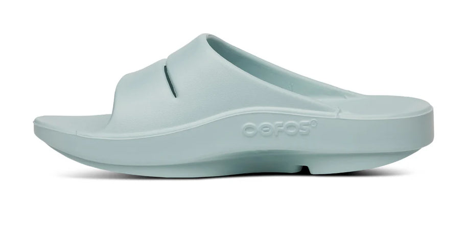 OOahh - Unisex by Oofos in pale blue with OOfoam strap for enhanced support, impact absorption, and comfort in slides designed for recovery and casual use