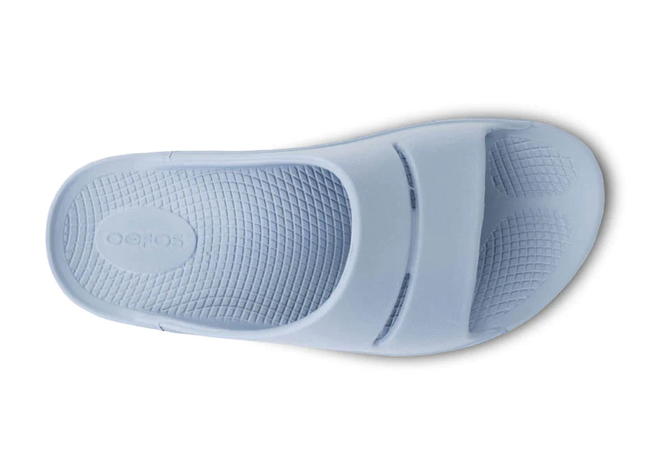 OOahh - Unisex by Oofos in light blue with OOfoam strap for extra support, impact absorption and comfort, ideal for recovery and casual wear