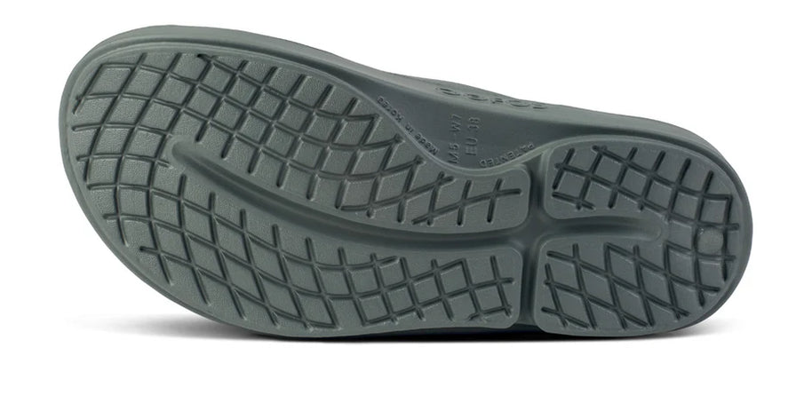 OOahh - Unisex by Oofos in dark grey with OOfoam strap, impact-absorbing slides designed for support and comfort in recovery and casual wear