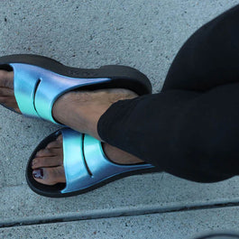 OOahh Luxe - Women by Oofos in blue metallic with agile OOfoam strap for support and comfort, durable slides ideal for casual wear and recovery