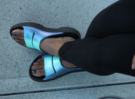OOahh Luxe - Women by Oofos in blue metallic with agile OOfoam strap for support and comfort, durable slides ideal for casual wear and recovery