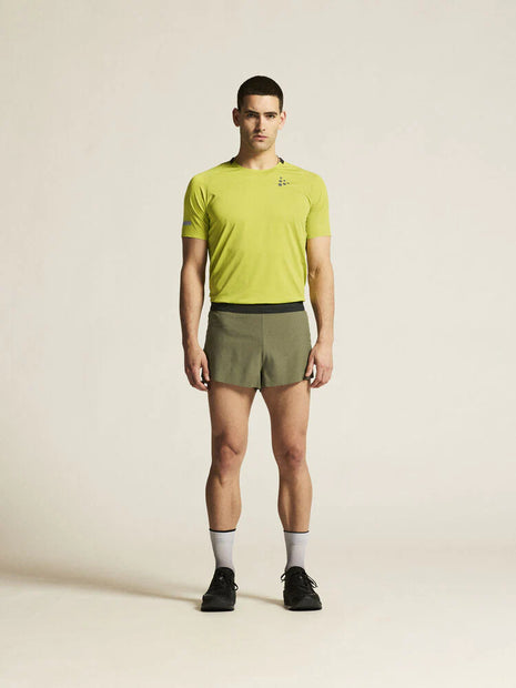 Man in a lime tee wearing Craft Pro Hypervent Split Shorts 2 in Rift, full-length front view