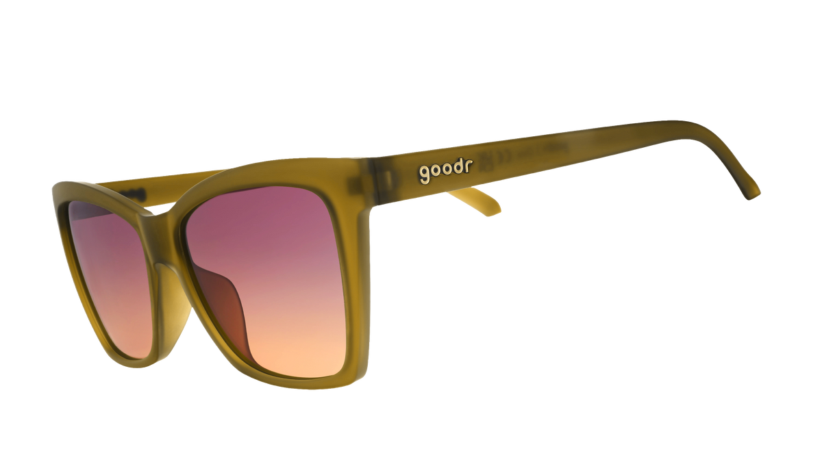 Goodr Sunbaked Sorcery sunglasses, side view of olive cat-eye frames with purple to peach gradient lenses
