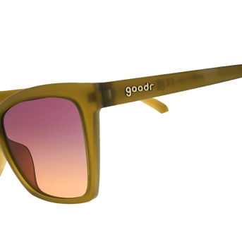 Goodr Sunbaked Sorcery sunglasses, side view of olive cat-eye frames with purple to peach gradient lenses
