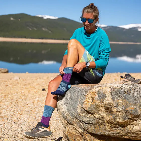 Trail Midweight Crew - Women by Injinji in blue and purple toe socks designed to reduce friction and provide comfort for rugged terrain running