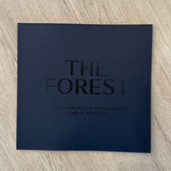 25 Years of the Cumberland Community Forest Society book in dark blue, featuring curated photos and evocative forest stories by local authors.