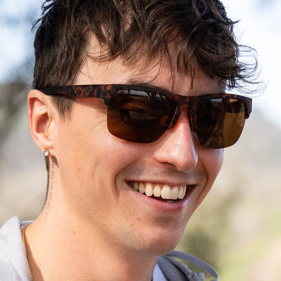 Country Club Crasher by Goodr in brown tortoiseshell half-rim sunglasses with dual-lens wrap frame and adjustable nose piece for stylish outdoor use