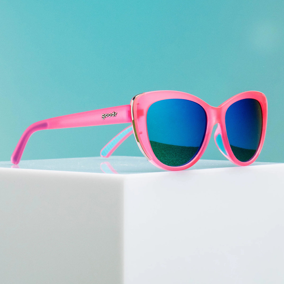 Flamingo Couture by Goodr in translucent pink with teal reflective lenses and chrome accents, stylish cat-eye sunglasses for fashion statements