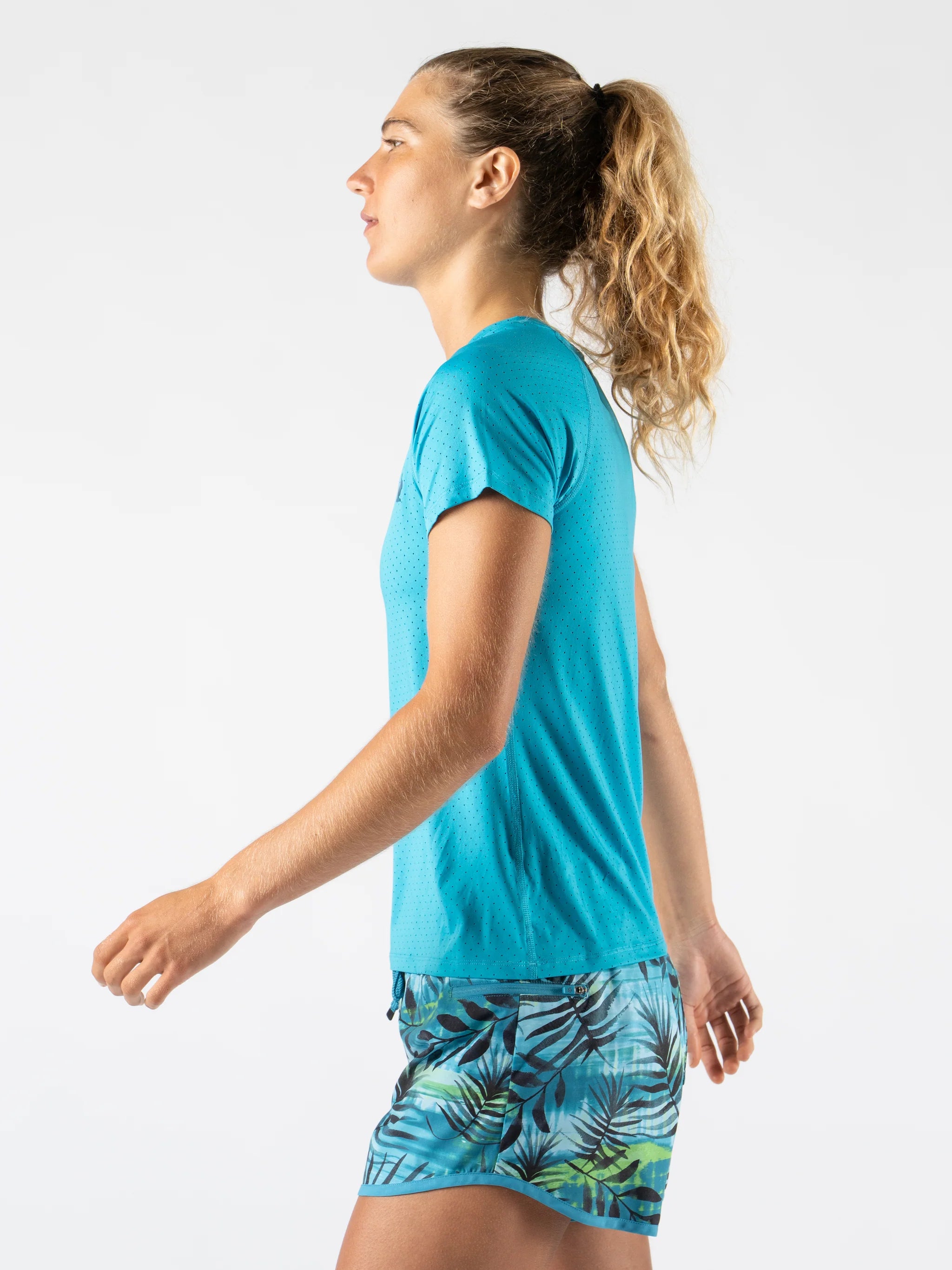 Woman wearing Rabbit ICE Perf Tee SS - Women in turquoise, lightweight, soft, perforated, quick-dry sustainable nylon perfect for running in Canada.