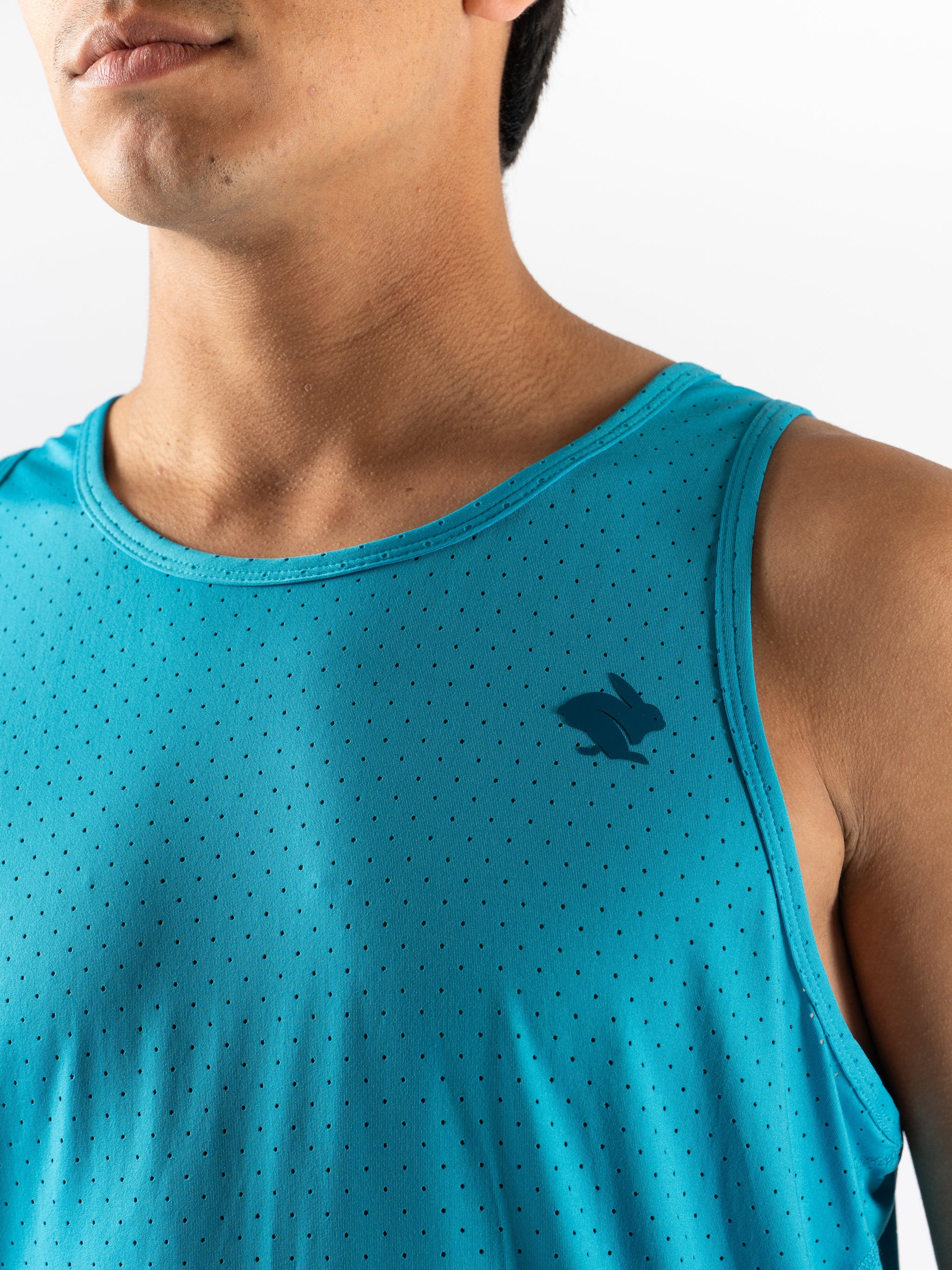Close-up of man wearing blue Ice Perf Tank - Men by Rabbit with breathable perforations and quick-dry sustainable nylon for running in Canada