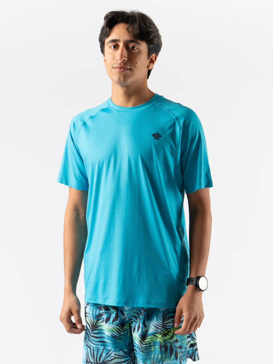 Man wearing turquoise ICE Perf Tee SS - Men by Rabbit, lightweight perforated sustainable nylon tee ideal for quick drying and active use.