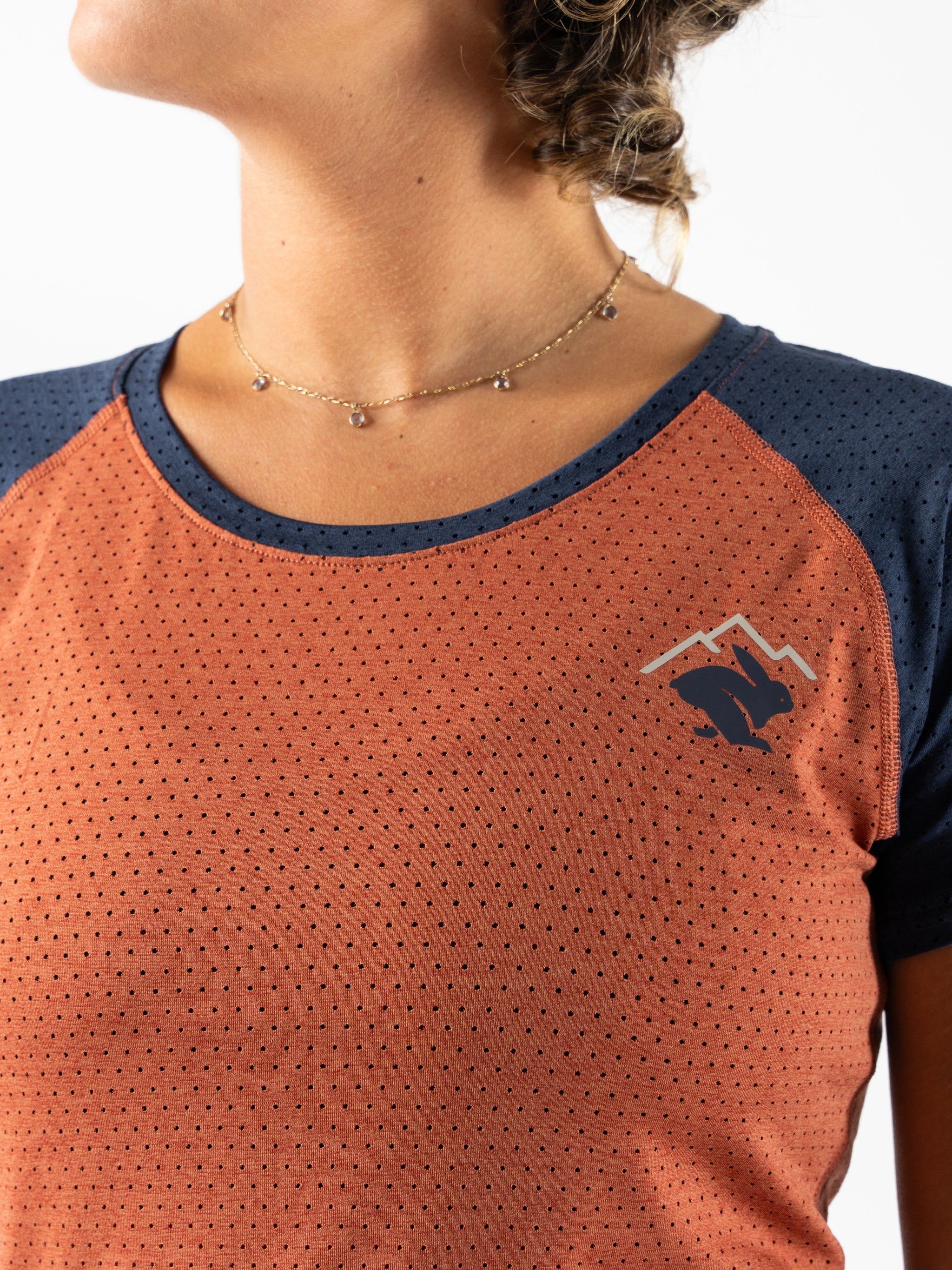 EZ Tee Perf SS Trail - Women by Rabbit in rust and navy with perforations for lightweight breathability, soft trail running top ideal for outdoor use