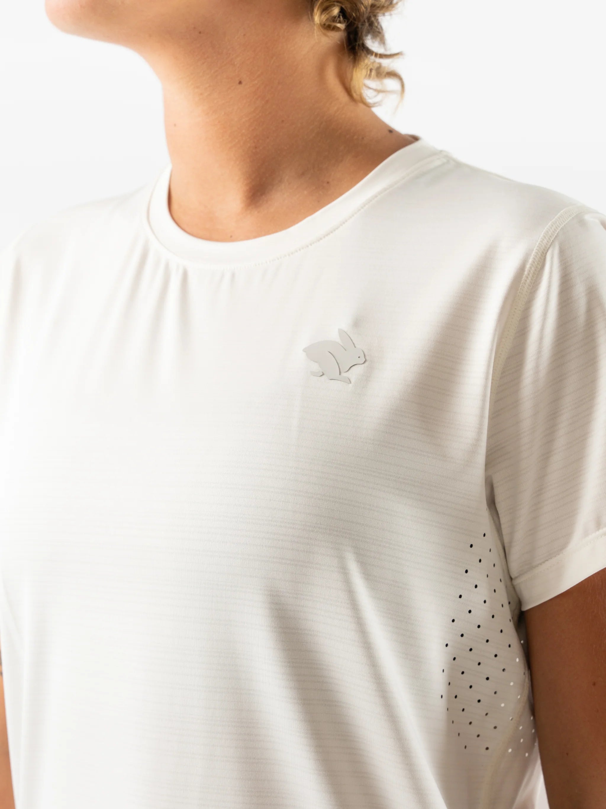 UPF Tee SS - Women by Rabbit in white, lightweight jersey with laser-cut arm perfs and UPF 50 protection for outdoor running.