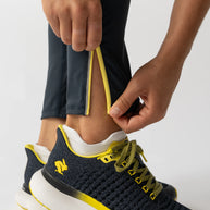 Low Light Speed Tights - Women by Rabbit in black with yellow trim, compressive fit, laser-cut perfs, five pockets, reflective running tights