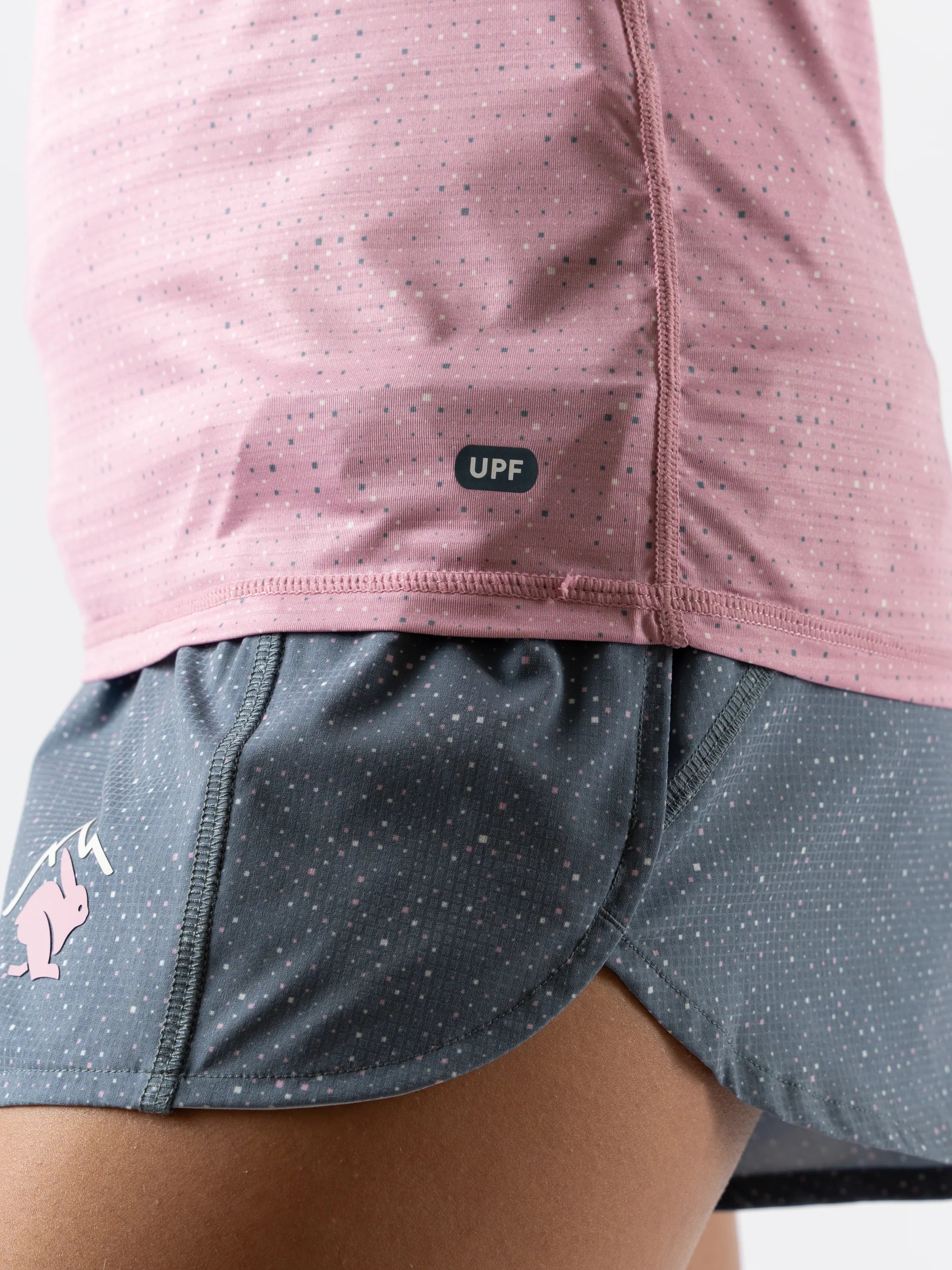 UPF Deflector 2.0 - Women by Rabbit in pink lightweight jersey with laser cut perfs, breathable sun protection top for running and outdoor use