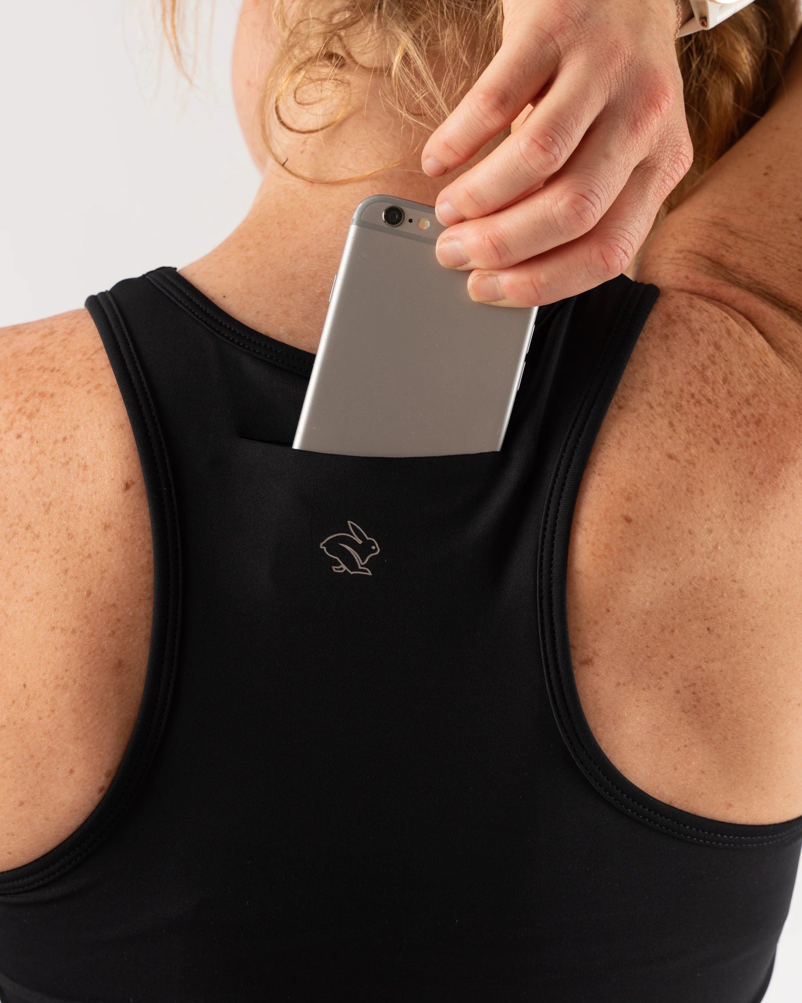 Utili Bra-Vo by Rabbit in black, multifunctional sports bra with laser-cut back pocket for essentials, minimizing bounce for running