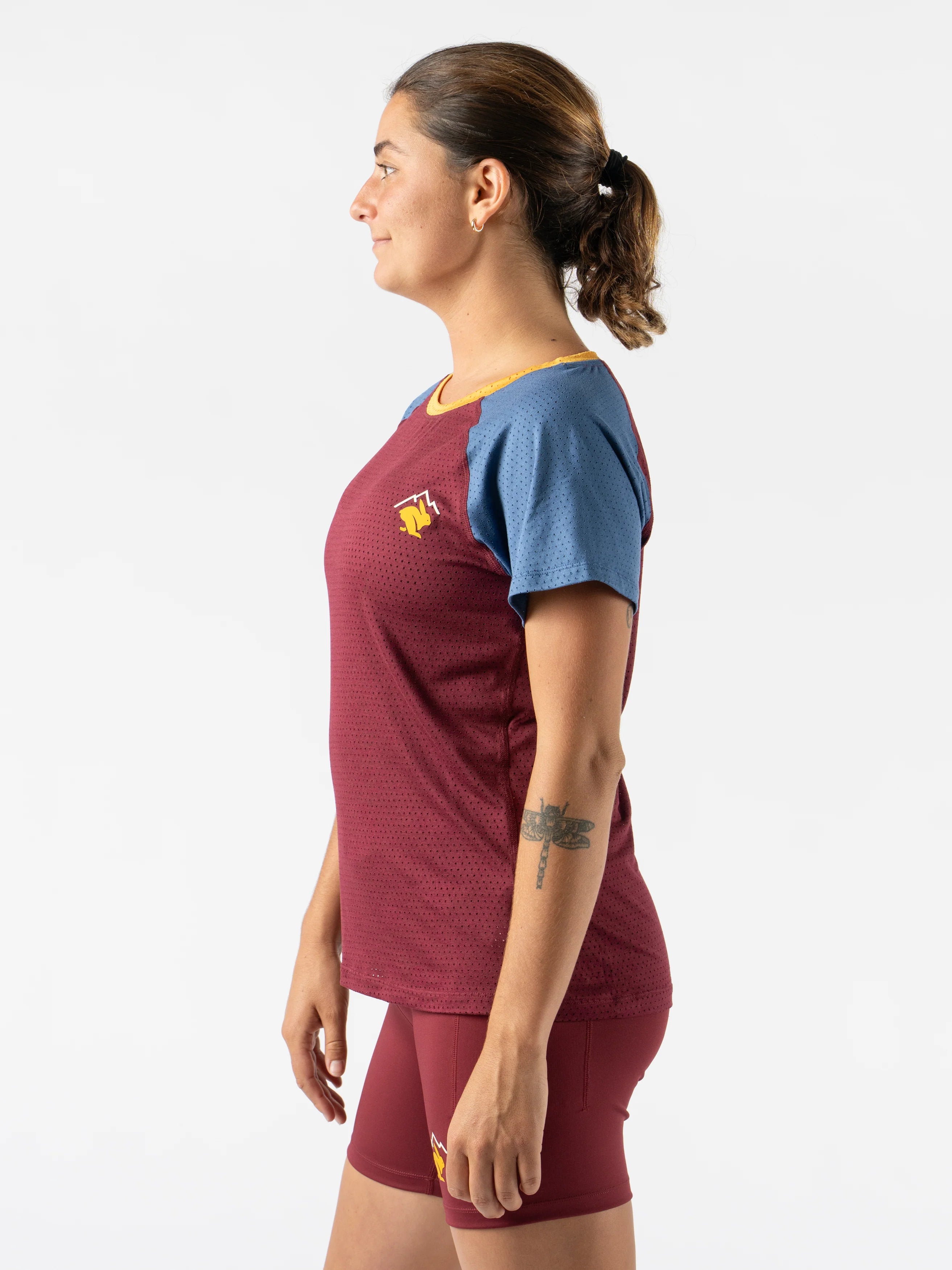 EZ Tee Perf SS Trail - Women by Rabbit in maroon and blue with breathable perforations, lightweight soft trail running top ideal for outdoor use