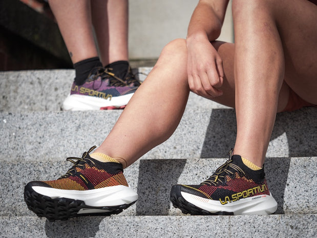 La Sportiva running shoe in black and yellow knit upper with thick cushioned sole, designed for trail running and outdoor use