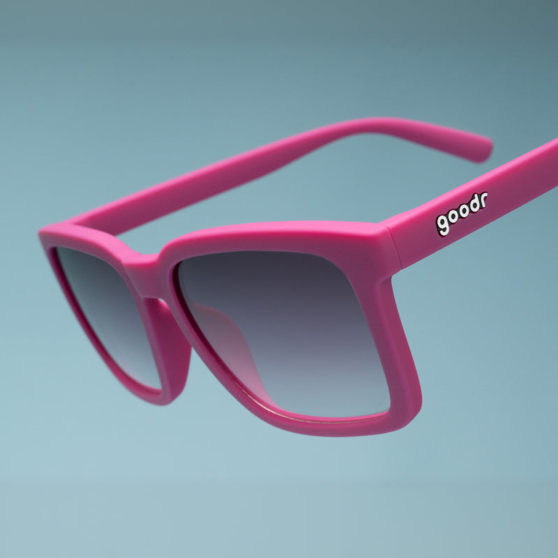 Close-up of the Goodr Living Highlight Reel magenta sunglasses showing the white goodr logo on the arm