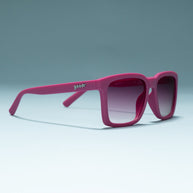 Goodr Living Highlight Reel magenta sunglasses standing open on a pale blue surface