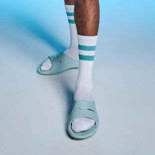 OOahh - Unisex by Oofos in light blue with OOfoam strap for extra support, impact absorption, and comfort for casual wear and recovery