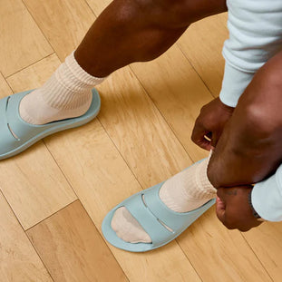 OOahh - Unisex by Oofos in light blue and beige with OOfoam strap cushioning for impact absorption and all-day comfort slides