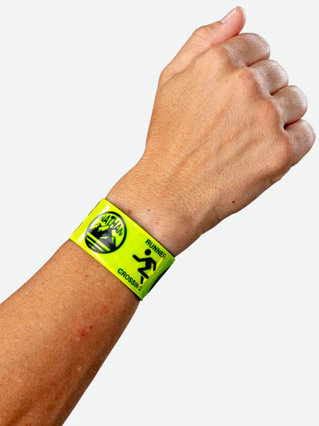 Nathan Reflex Bands in Hi Viz Yellow wrapped around a wrist against a light background