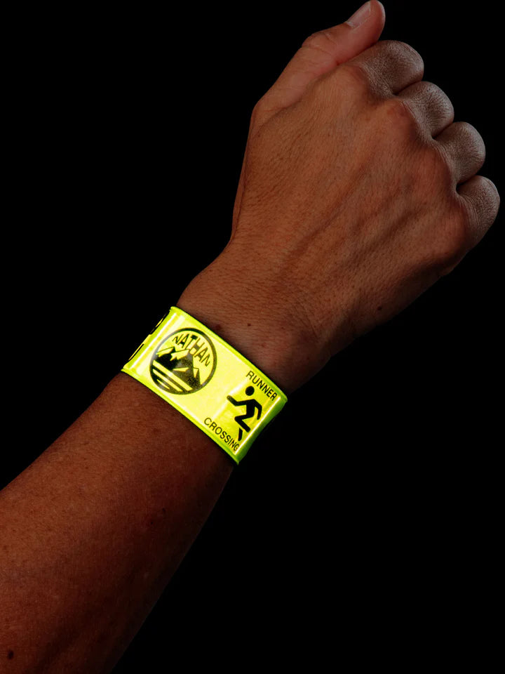 Nathan Reflex Bands in Hi Viz Yellow on a wrist against a black background