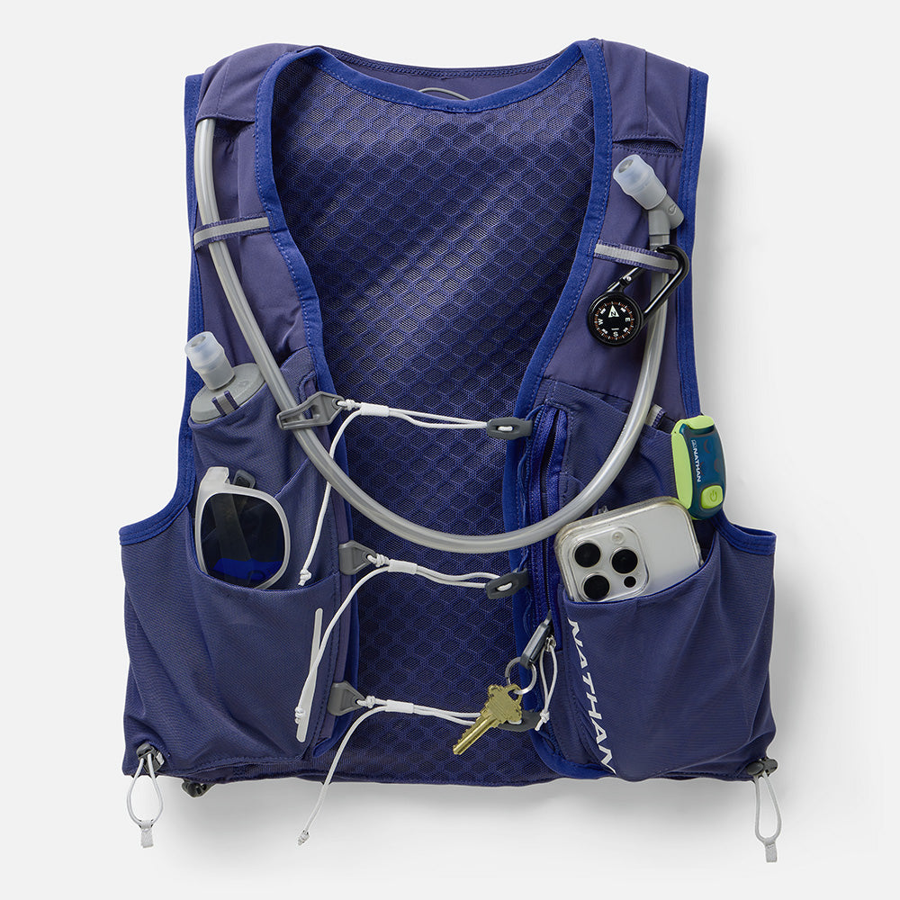 Nathan Pinnacle Pro 12L women's vest in Indigo/Light Blue, front pockets loaded with phone, keys and gear