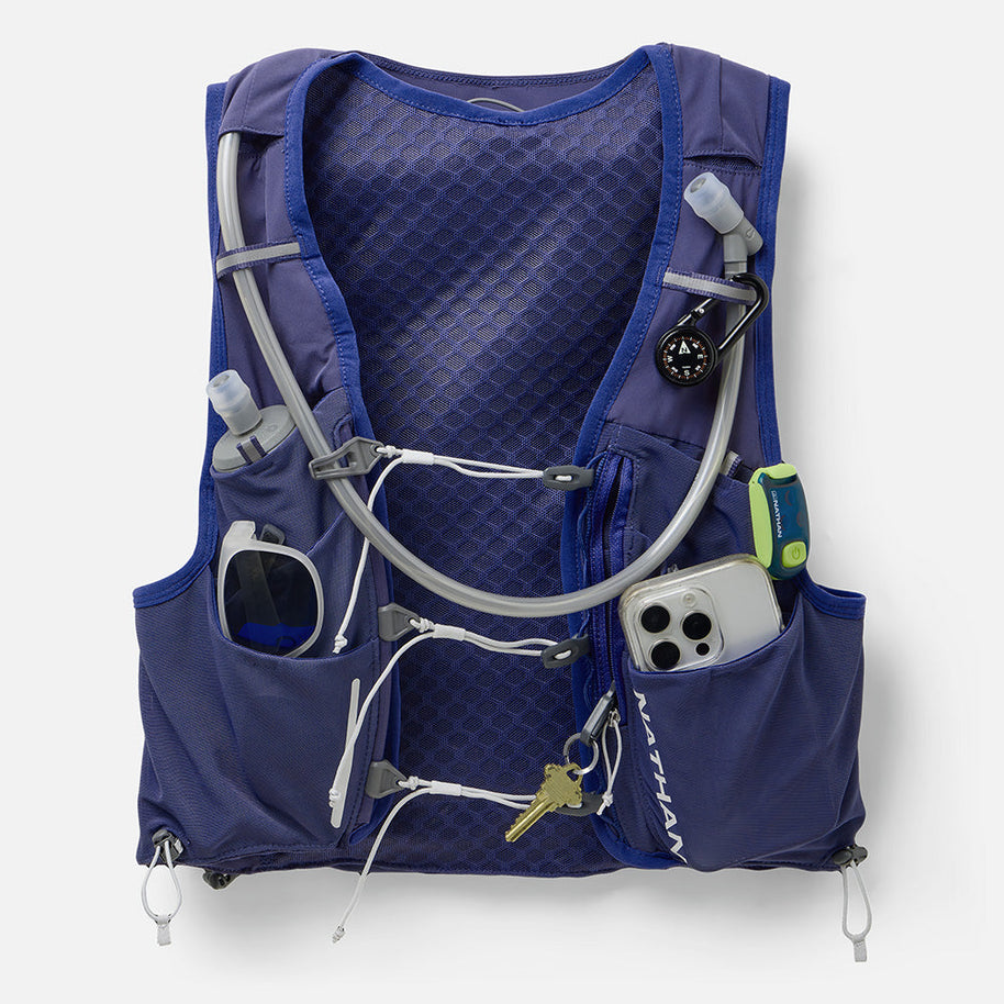 Nathan Pinnacle Pro 12L women's vest in Indigo/Light Blue, front pockets loaded with phone, keys and gear