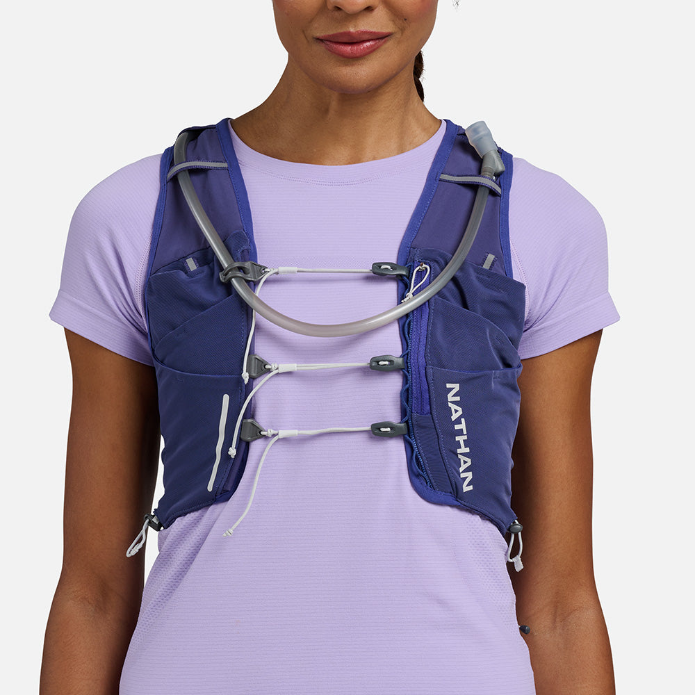Woman wearing the Nathan Pinnacle Pro 12L running vest in Indigo/Light Blue, front view