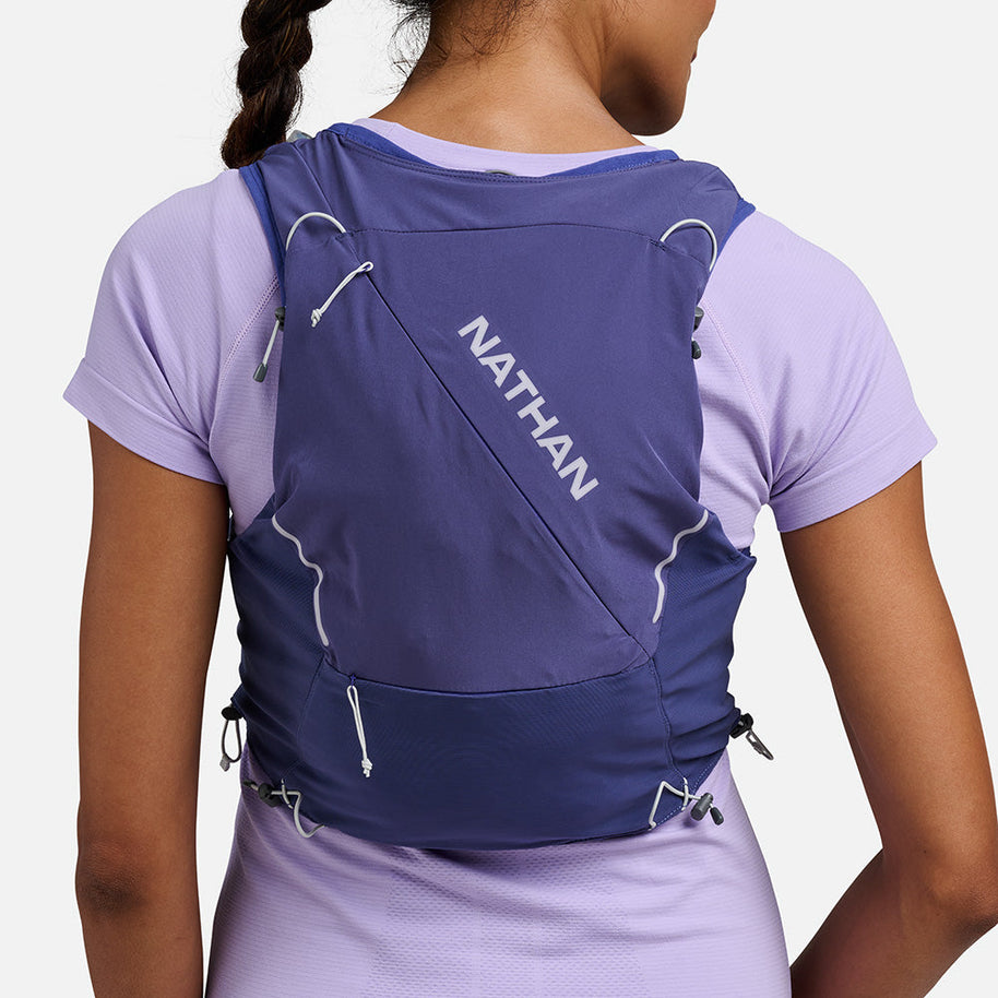 Woman wearing the Nathan Pinnacle Pro 12L running vest in Indigo/Light Blue, back view