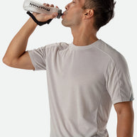 ExoShot Lite 14oz Handheld by Nathan in clear with black strap, soft flask with rigid ExoSpine for comfort and efficient hydration during running