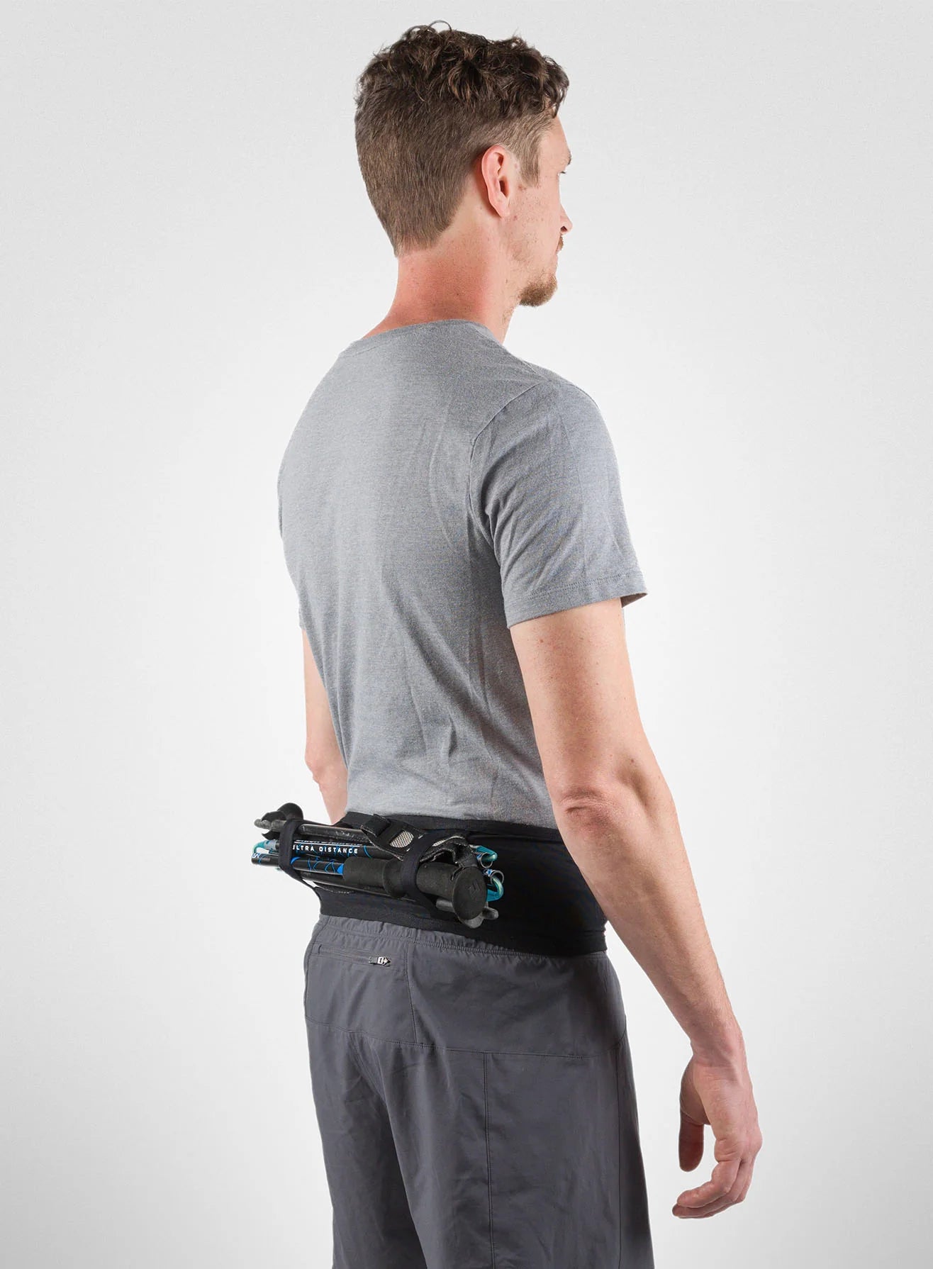 Running Band by Naked in black, high-performance waist belt carrying trekking poles, fuel, and accessories for running and outdoor use