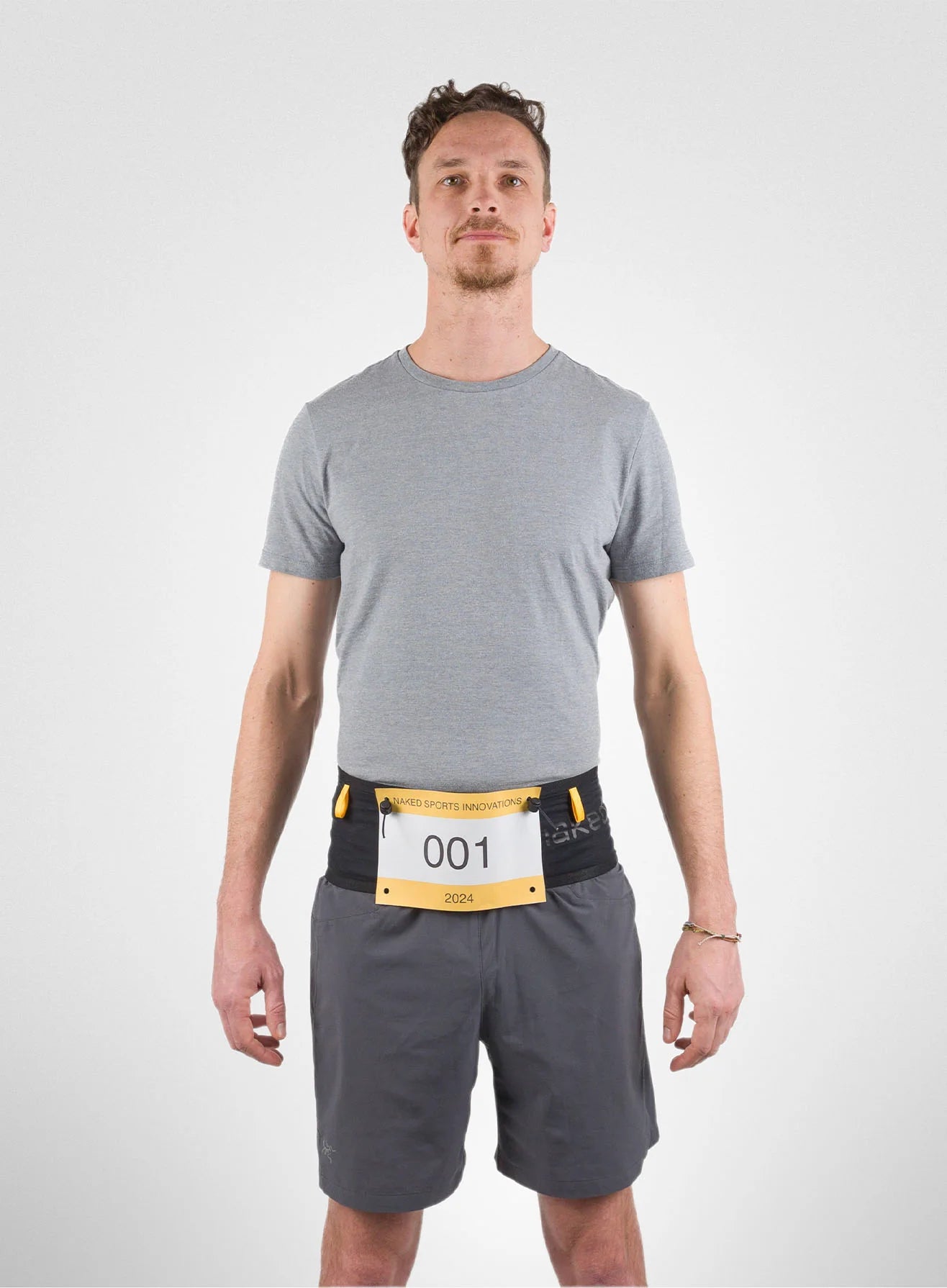 Running Band by Naked in black and yellow, high-performance waist belt for carrying fuel, fluids, accessories, ideal for running and trekking.