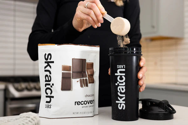 Sport Recovery Drink Mix chocolate by Skratch Labs in white bag with chocolate pieces, nutrition for rapid refuel and rehydrate