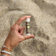 Lipbalm SPF 30 by Sun Bum in brown with white cap, moisturizing lip care with Aloe and Vitamin E for sun protection outdoors
