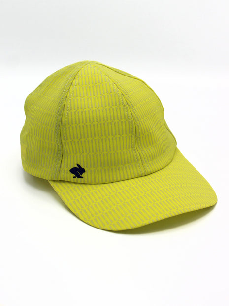 Low Light Tech Cap by Rabbit in bright yellow with reflective pattern, designed for visibility and safety during night running and outdoor use