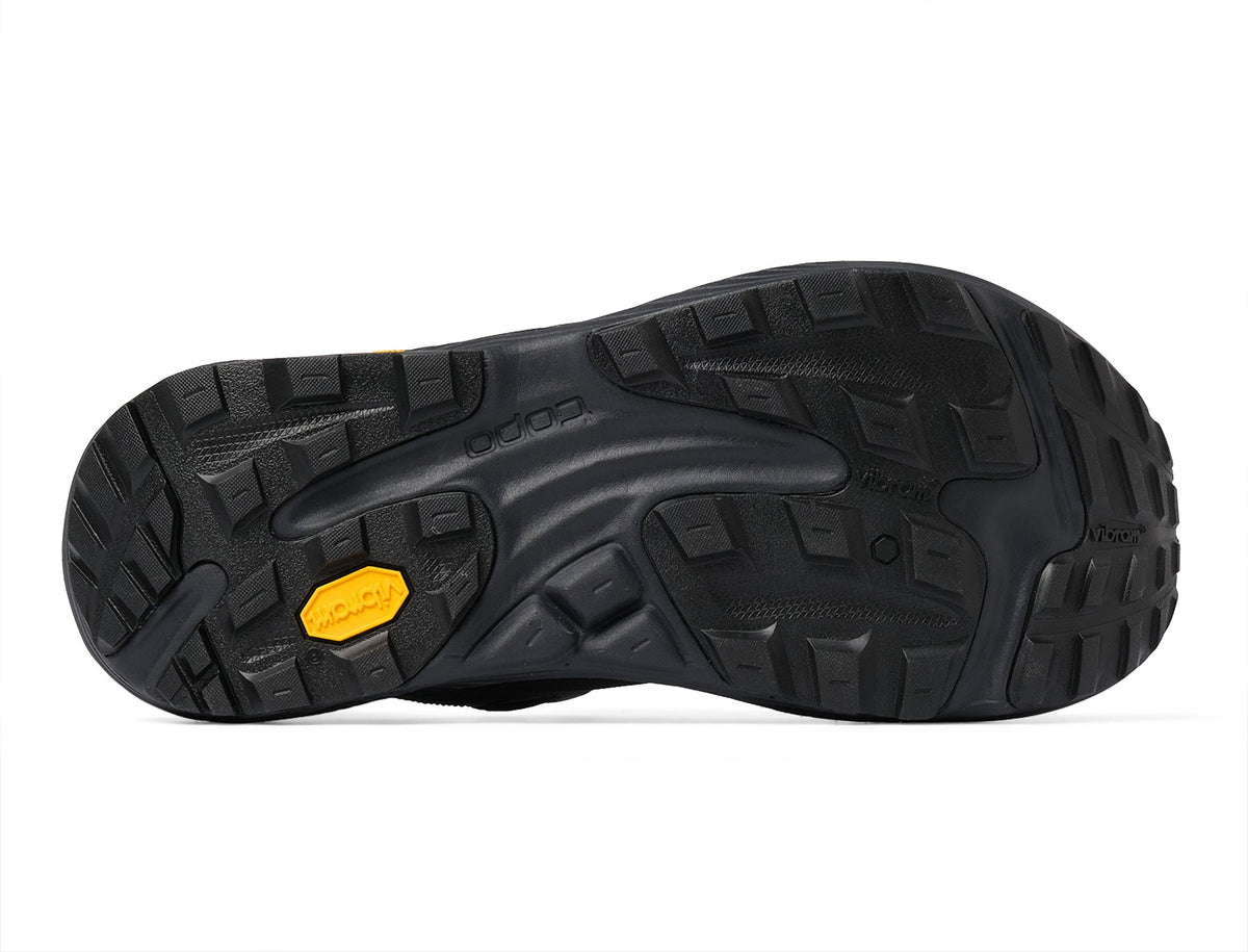 Black lugged Vibram outsole of the Topo Ultraventure 5 GTX women's trail running shoe in Grey/Butter