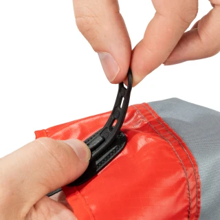 Hands adjusting the black strap on the red lower panel of the Kahtoola LEVAgaiter GTX Mid in Cardinal