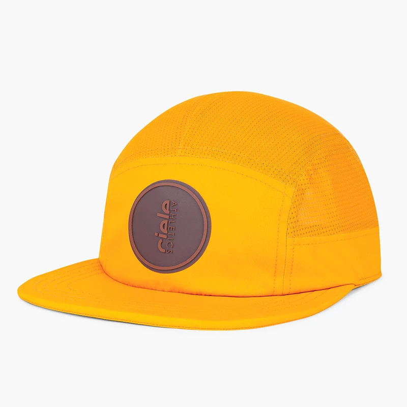 Ciele GOCap Comp Ninety in Solis, orange-yellow five-panel cap with round brown patch, front three-quarter view