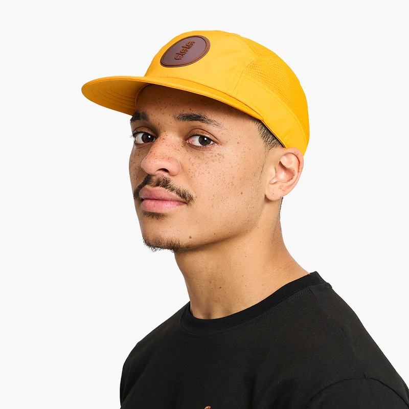 Man wearing the Ciele GOCap Comp Ninety in Solis, three-quarter view showing the brown patch