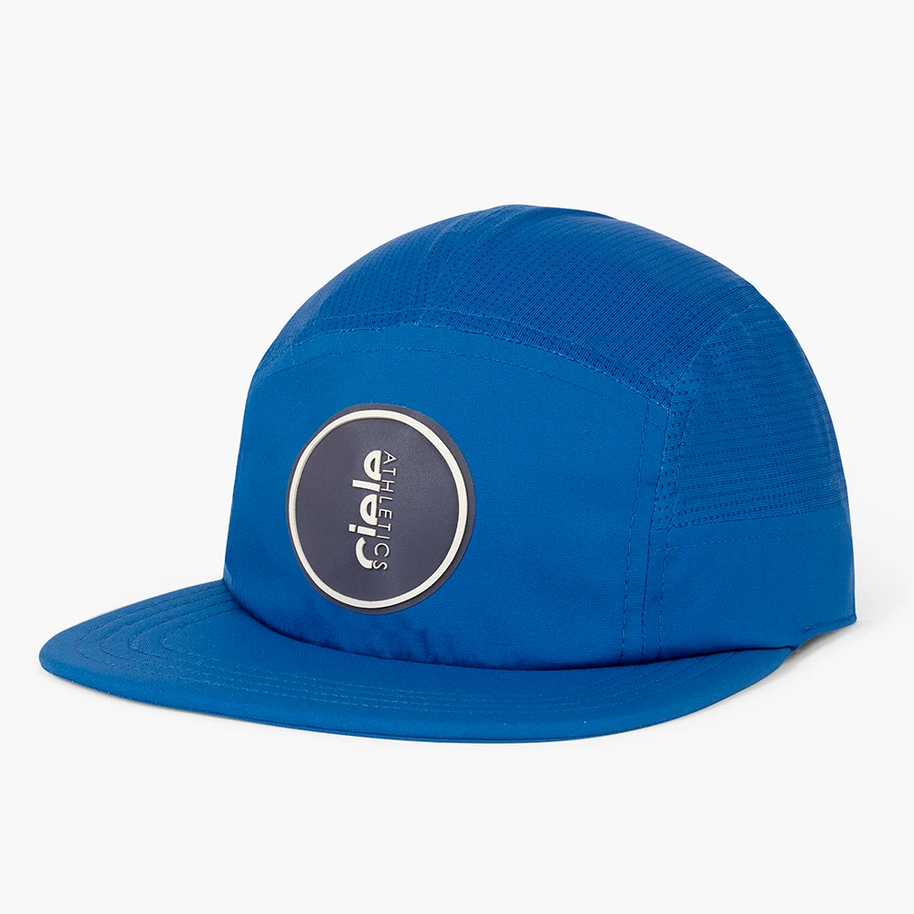 Ciele GOCap Comp Ninety in Azure, bright blue five-panel cap with round navy patch, front three-quarter view
