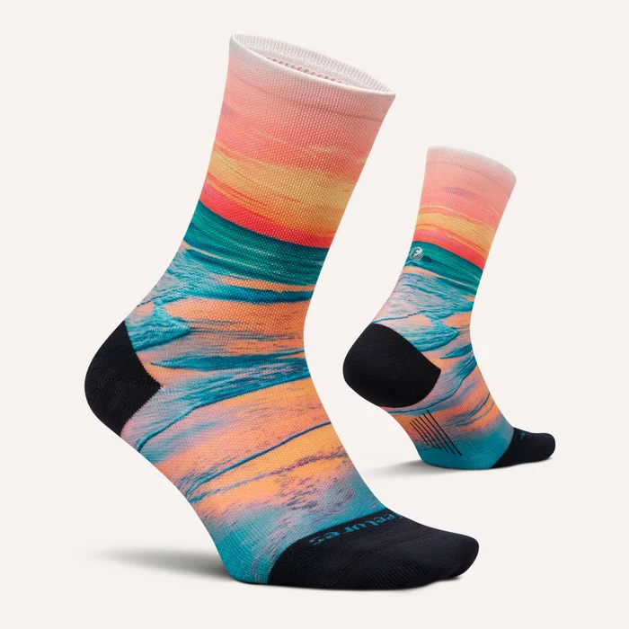 Pair of Feetures Elite Light Cushion Mini Crew socks in Sunset Glow with orange and teal sunset print