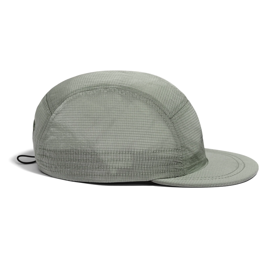 Side view of the Norda Luster Cap in Sage with the cord toggle visible at the back